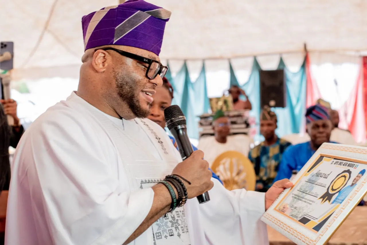 Dr. Rasheed Olayinka Alausa speaking while holding a recognition certificate